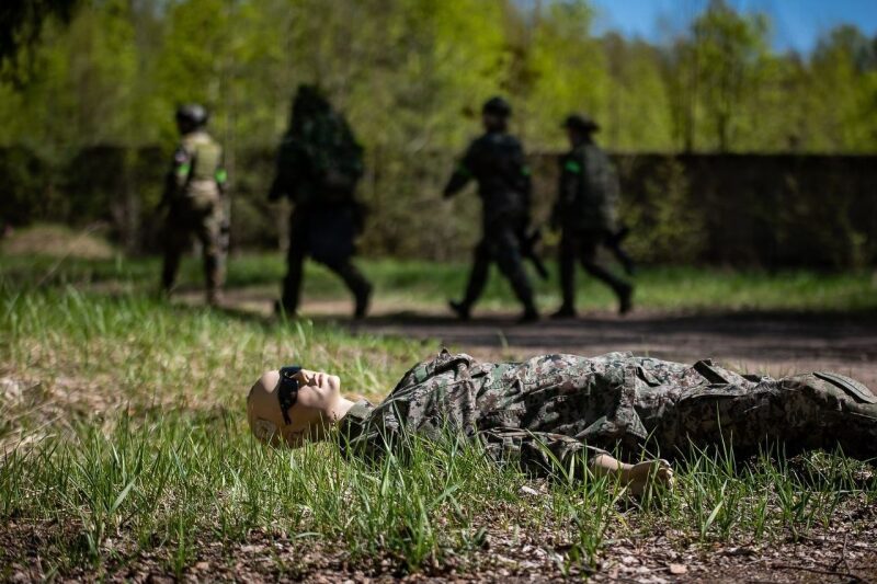 Учебный бой: манекен в камуфляже лежит на траве.