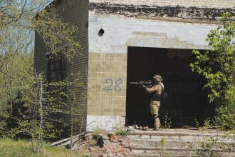 Игрок LASERWAR занимает позицию у входа в здание.