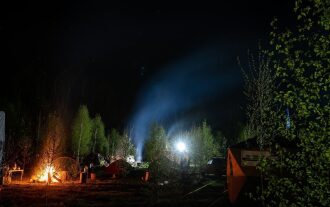 Ночной лагерь LASERWAR: костер и прожекторы освещают поляну