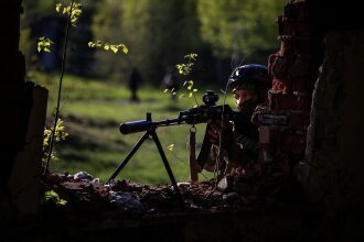 Боец LASERWAR ведет прицельный огонь из укрытия