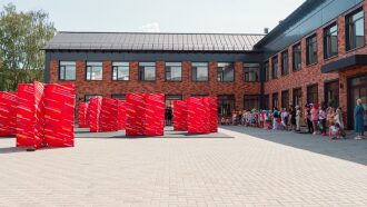 Дети в ярких нарядах выстроились у красных стендов LASERWAR.