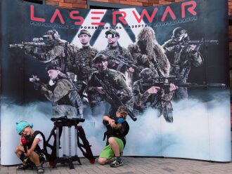 Дети с оружием LASERWAR перед баннером