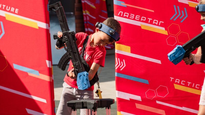 Мальчик в красной футболке с оружием LASERWAR