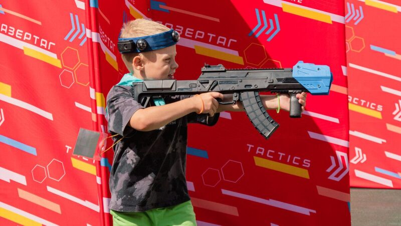 Мальчик с автоматом LASERWAR прицеливается в сторону.