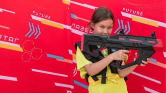 Девочка с футуристическим автоматом LASERWAR готова к игре.