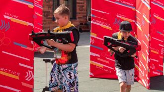 Два мальчика с футуристическим оружием LASERWAR готовы к бою.