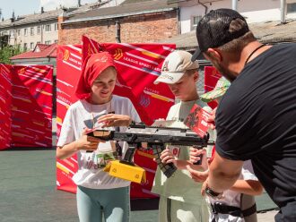Девочка с автоматом LASERWAR получает инструкции от инструктора.