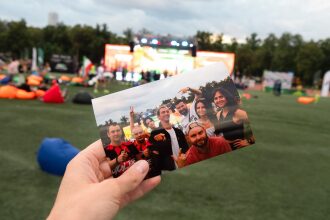 Друзья позируют на фотокарточке на фоне мероприятия.