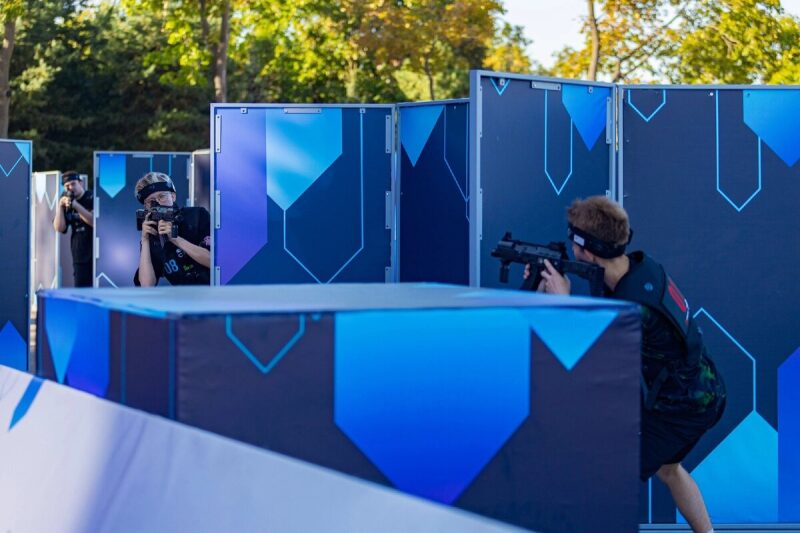 Игроки LASERWAR в движении на арене с укрытиями.