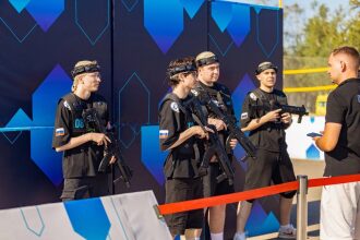 Игроки LASERWAR ожидают начала игры у яркой стены.