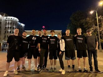Команда LASERWAR позирует на фоне ночного города.