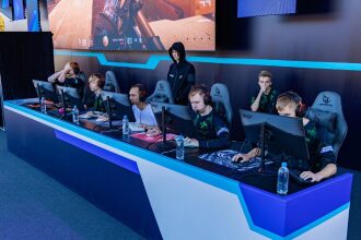 Игроки LASERWAR сосредоточены на мониторах, один игрок стоит.