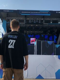 Парень в черной футболке с номером 27 смотрит на сцену.