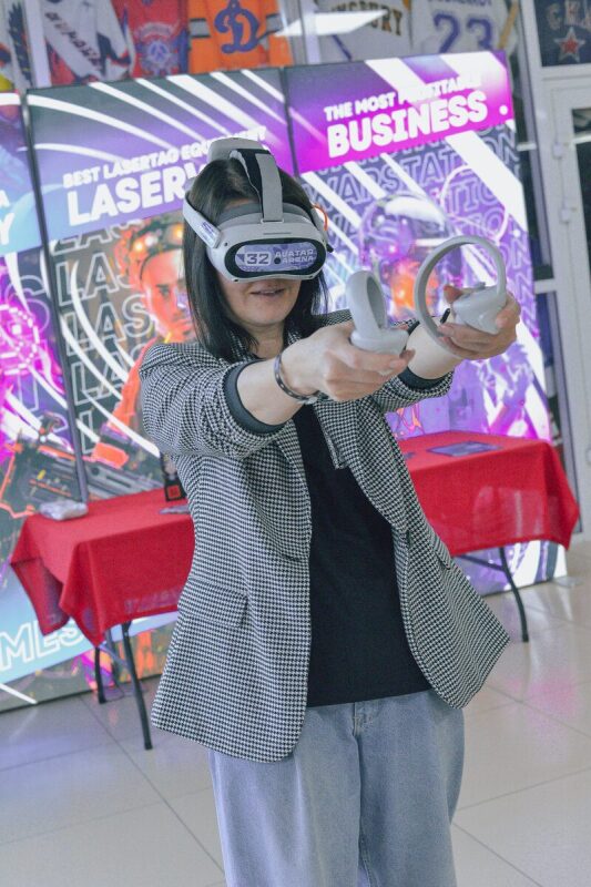 Девушка в VR-очках LASERWAR с контроллерами в руках.