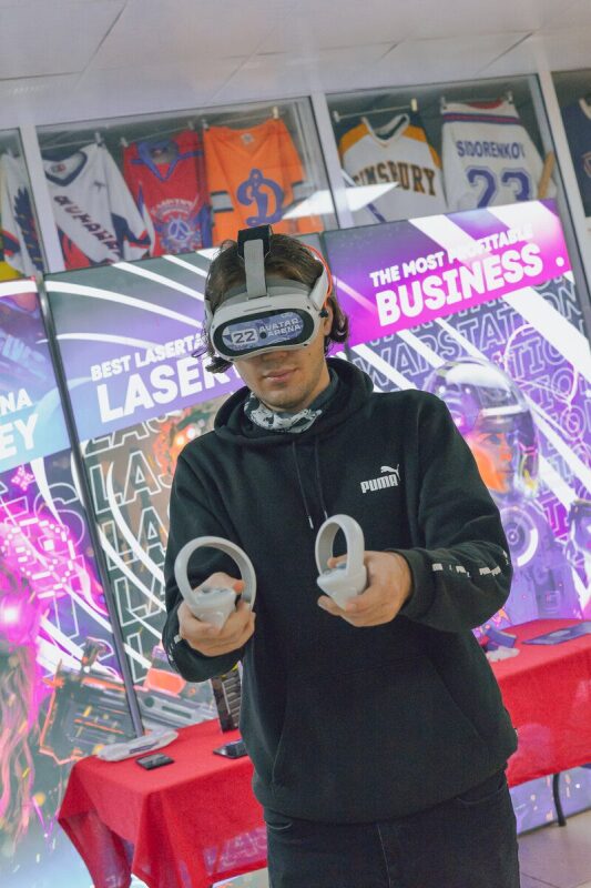 Молодой человек в VR-гарнитуре с контроллерами