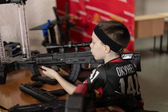 Мальчик с прицелом изучает лазертаг-винтовку LASERWAR.