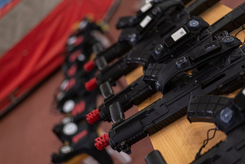 Ряд черных лазертаг-винтовок LASERWAR с красными дульными насадками.