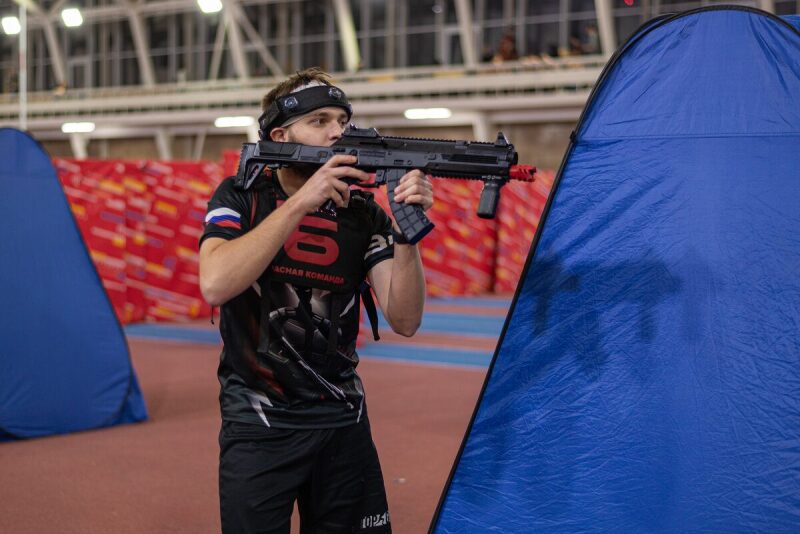 Игрок LASERWAR прицеливается из современного автомата