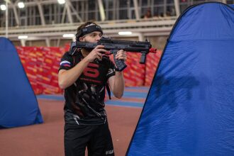 Игрок LASERWAR прицеливается из современного автомата