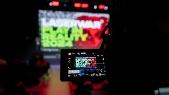 Камера снимает экран с логотипом LASERWAR Play in Reality 2024