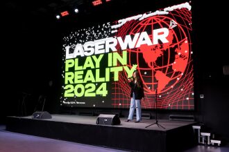 Девушка с микрофоном на сцене перед экраном LASERWAR