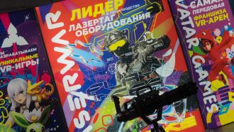 Макет лазертаг-оружия на фоне ярких баннеров LASERWAR.