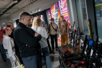 Группа людей рассматривает лазертаг-оружие LASERWAR.
