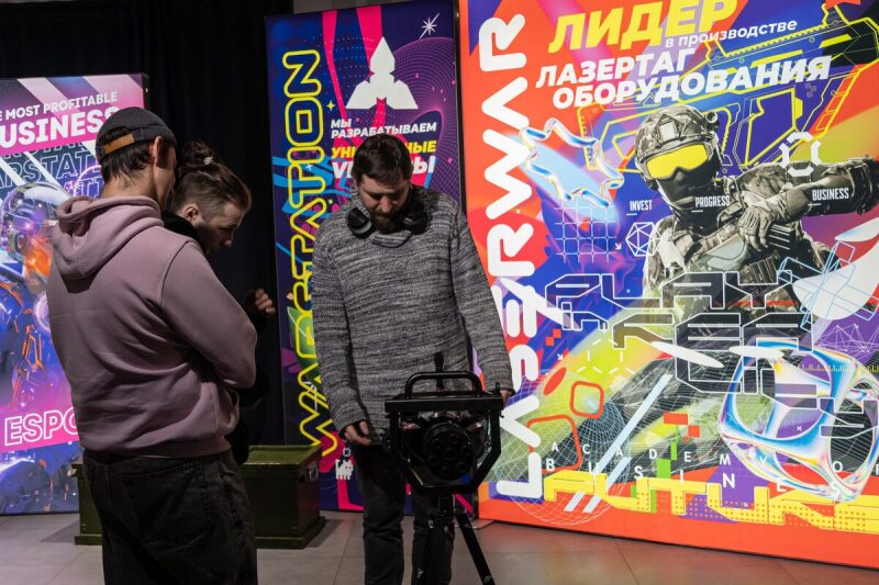 Мужчина настраивает оборудование LASERWAR на штативе.