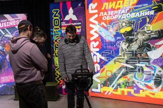 Мужчина настраивает оборудование LASERWAR на штативе.