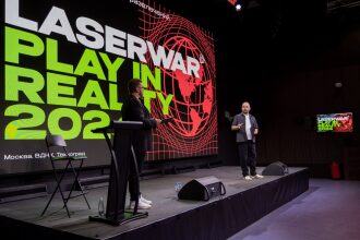 Два спикера LASERWAR на сцене перед огромным экраном.