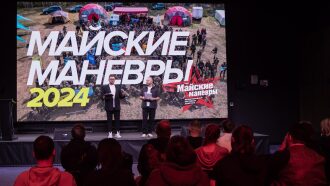 Два ведущих представляют "Майские маневры 2024" на сцене.