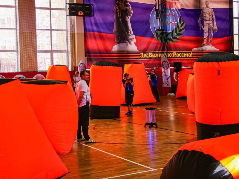 Игроки LASERWAR в синей форме на арене с препятствиями.
