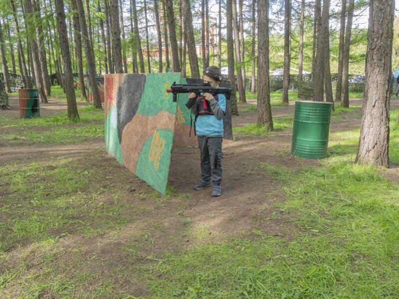Юный игрок LASERWAR ведет огонь из-за укрытия.