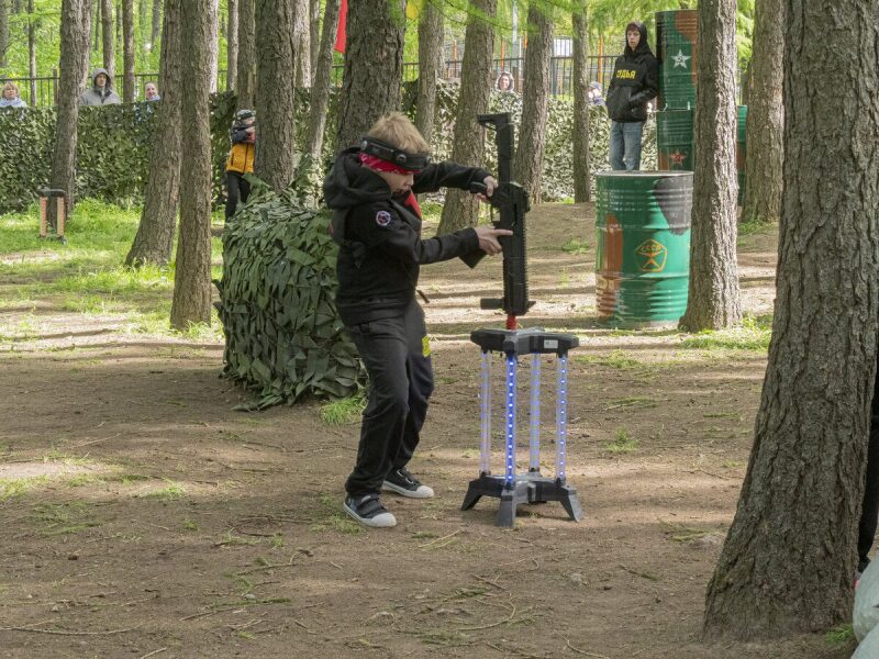 Игрок LASERWAR заряжает бластер на специальной подставке.