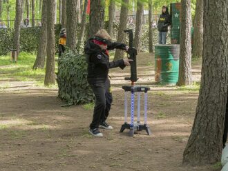 Игрок LASERWAR заряжает бластер на специальной подставке.