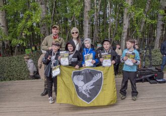 Команда с флагом и грамотами LASERWAR празднует победу.