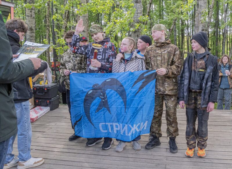 Команда «Стрижи» с флагом и кубком празднует победу.