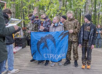 Команда «Стрижи» с флагом и кубком празднует победу.