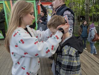 Девушка вручает медаль юному победителю лазертага