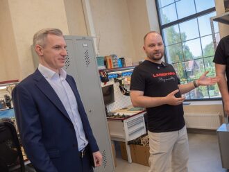Представитель LASERWAR демонстрирует оборудование гостю.