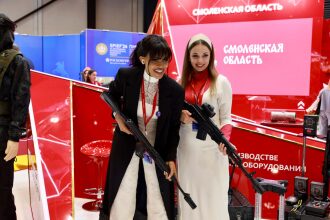Две девушки с лазертаг-оружием на выставке