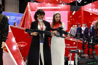 Две девушки демонстрируют лазертаг-оружие на форуме 2026