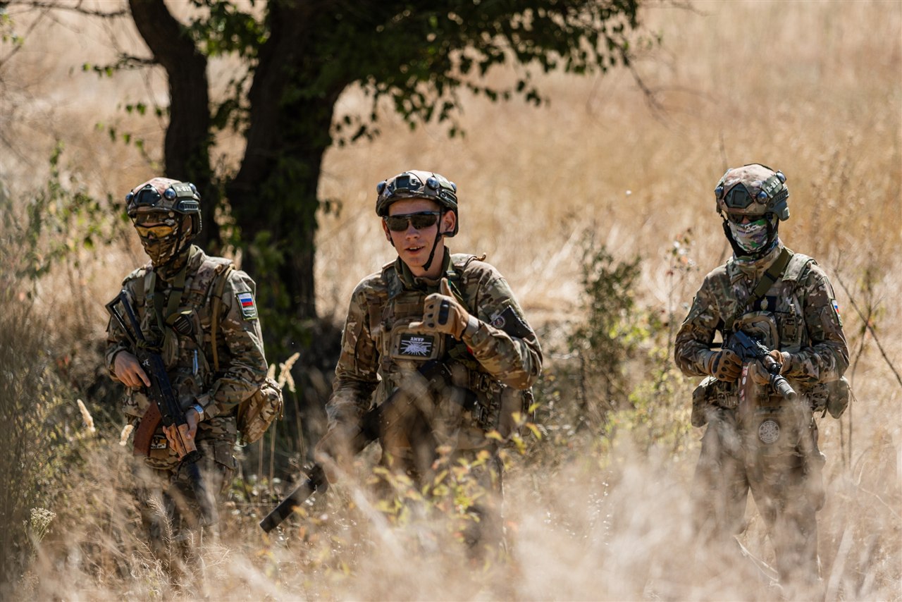 Старшая возрастная категория, лазертаг: Группа у большого дерева, рядом белый указатель