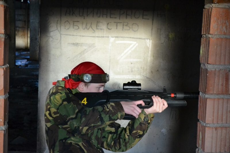 Юный стрелок LASERWAR в засаде у кирпичной стены