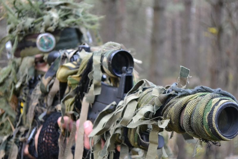 LASERWAR: снайпер в маскировке готовится к выстрелу.