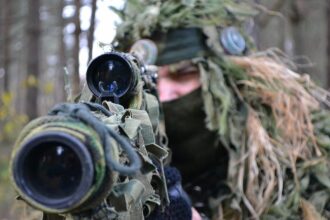 LASERWAR: снайпер в маскировке выцеливает цель.