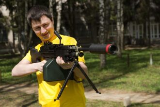 Боец в желтом готов к сражению с пулеметом LASERWAR