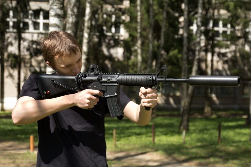 Боец LASERWAR с винтовкой и глушителем готовится к игре.
