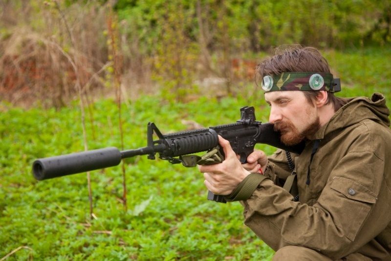 Игрок LASERWAR в камуфляже целится из автомата