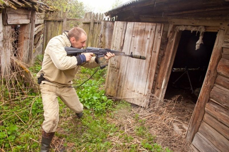 Игрок LASERWAR наводит оружие на заброшенное строение.